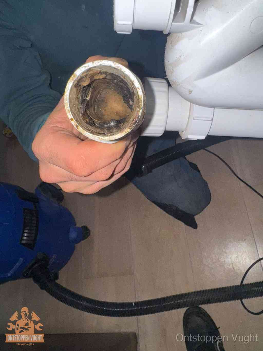 Een losgekoppelde afvoerbuis die van binnen volledig is dichtgeslibd met vet en aanslag, de meest voorkomende oorzaak van een verstopte gootsteen in Vught