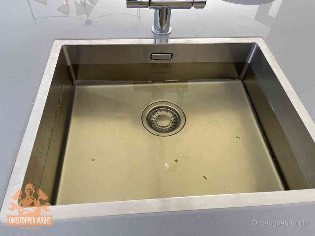 Stilstaand water in een rvs spoelbak dat niet wegloopt, een duidelijk signaal van een gootsteenverstopping in Vught