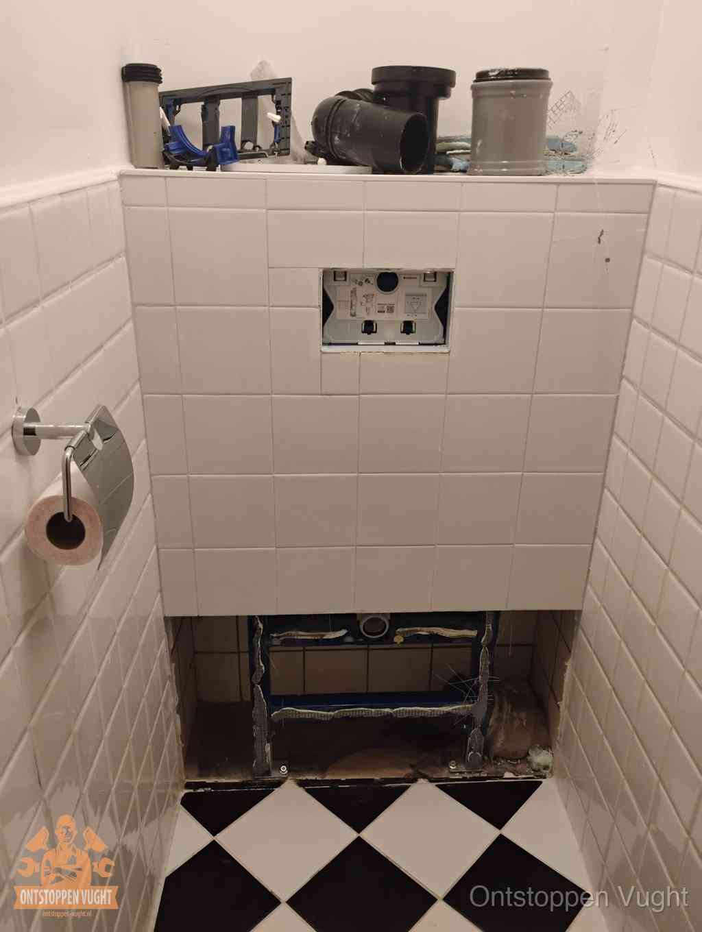 Een toiletruimte waar het hangtoilet en de inbouwreservoir-onderdelen zijn vrijgelegd voor onderhoud, periodiek nazicht voorkomt een wc-verstopping in Vught